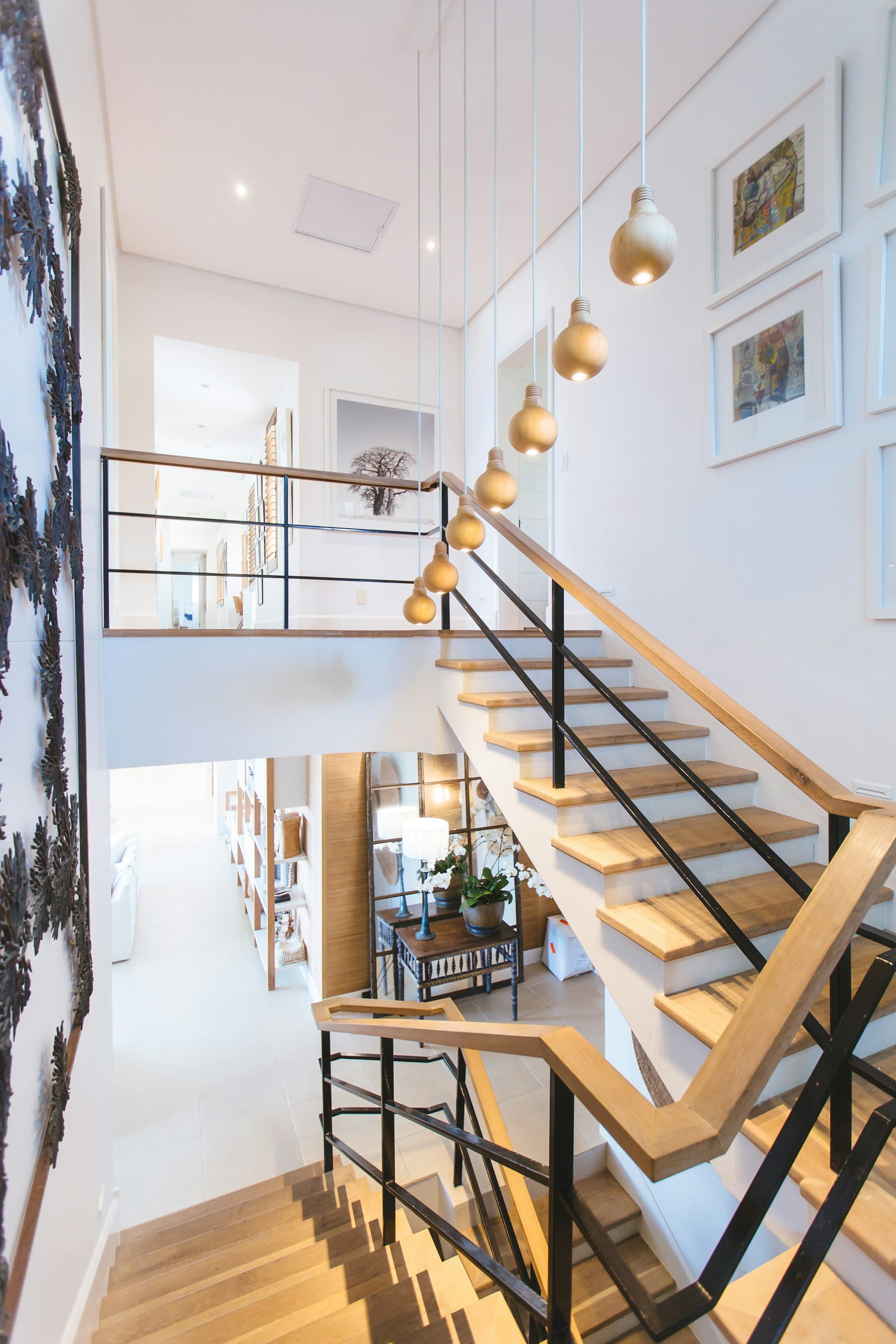 The new stair of oak and blackened steel, suspended in the former light well. Brass pendants trace its ascent.