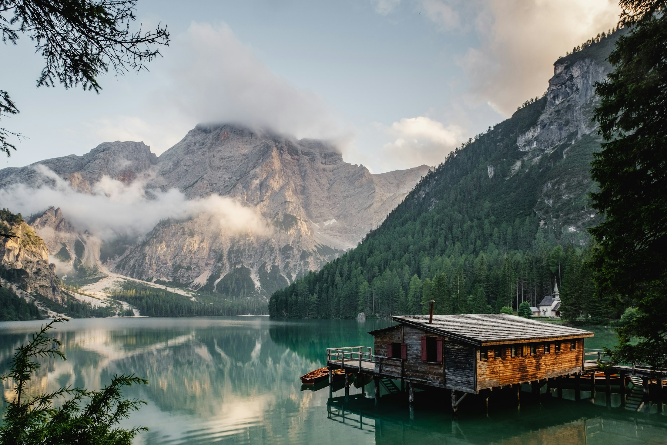 Site study: the boathouse that has stood on the lake for a century — proof of how little the shore needs.
